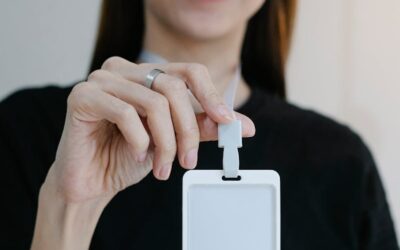 Portrait d'une femme joyeuse tenant un badge d'identification vierge, parfait pour la promotion d'une entreprise ou d'un événement.